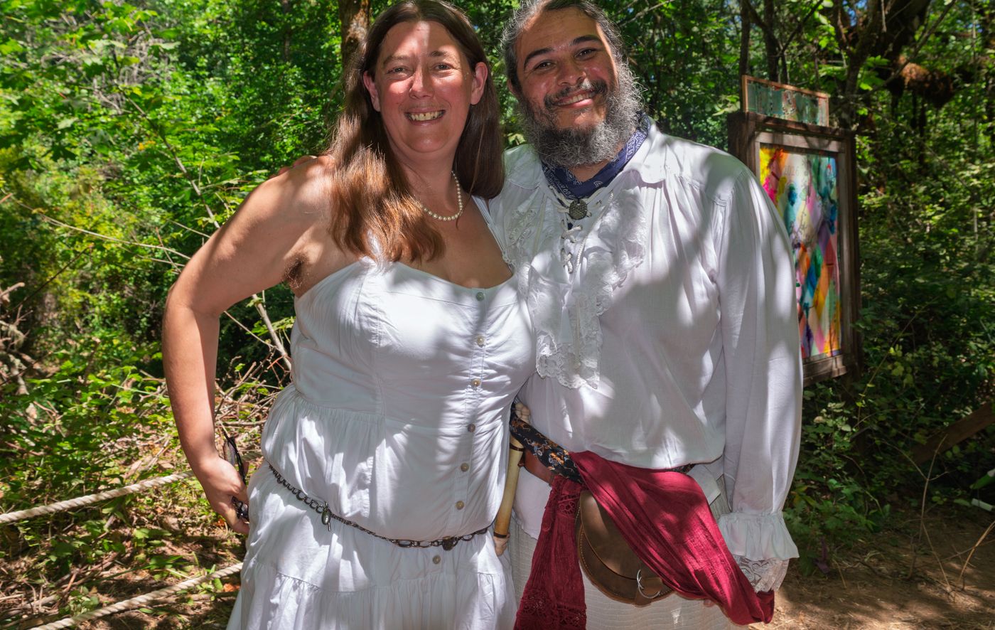 The couple smiling in the forest